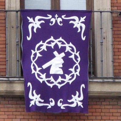 Colgadura morada con el emblema de la cofradía en un balcón